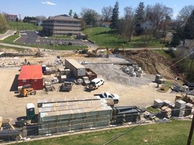 A scene of the construction of WVU Tech's Elab building, where trucks and materials are scattered over the packed dirt of the construction site.